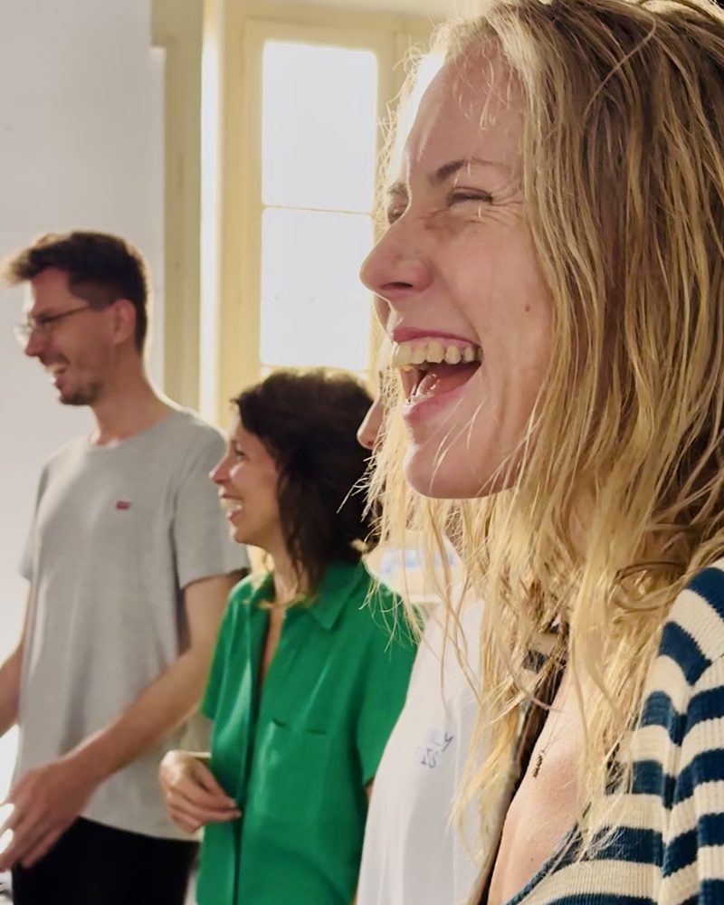 A participant laughing hard while the others talk beside her