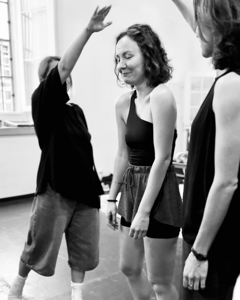 A participant reaching an arm high above the group, the others laughing