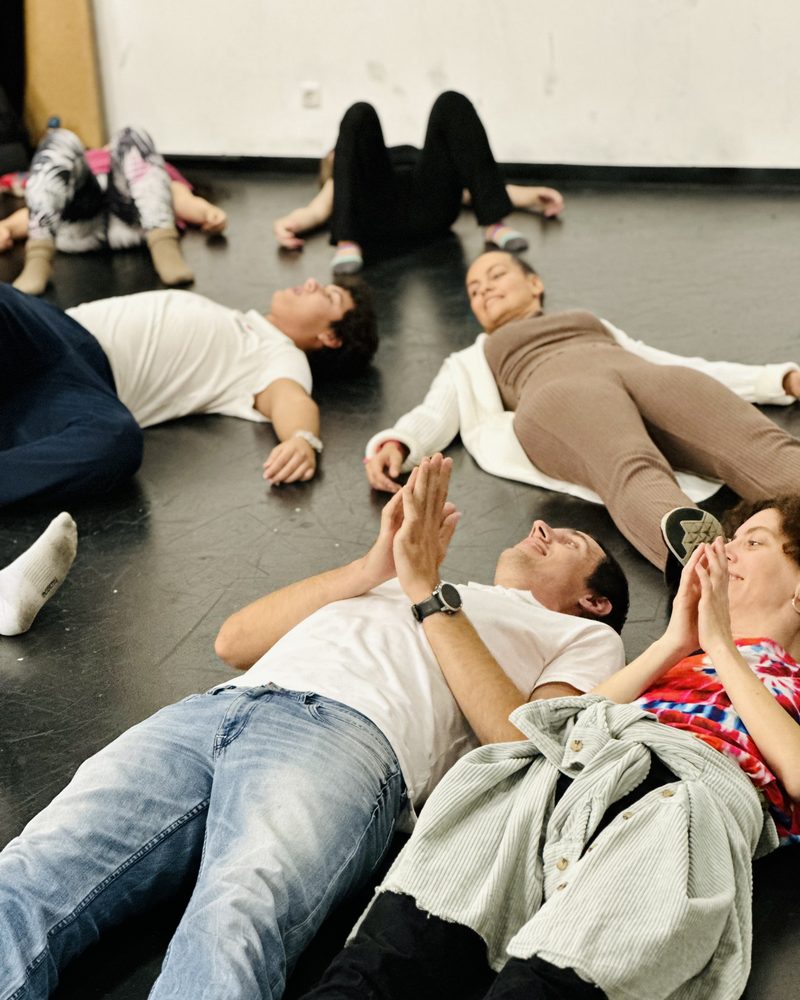 The whole group lying on the floor across the room