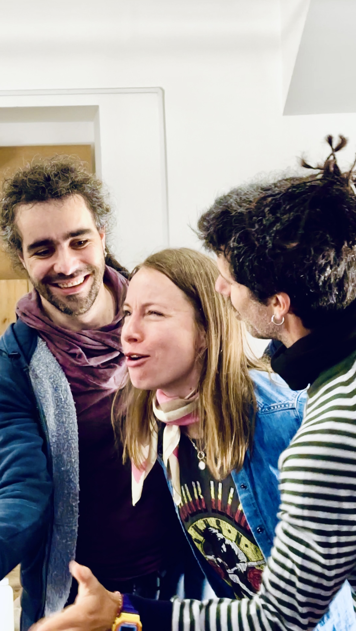 Three participants pressed close together mid-laugh, one of them talking over the other two